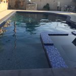 Pool with Spa Add on with dark coping and concrete deck