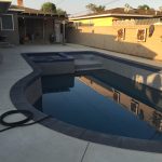 Pool and Spa with dark gray coping and pebble finish