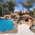 Pool with rookwork, slide, grotto and white pavers