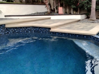 pool with 1x1 tiles and steps to raised bond beam